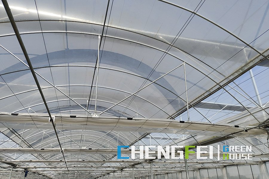CFGET film greenhouse roof ventilation linkage and drive components viewed from the crop zone